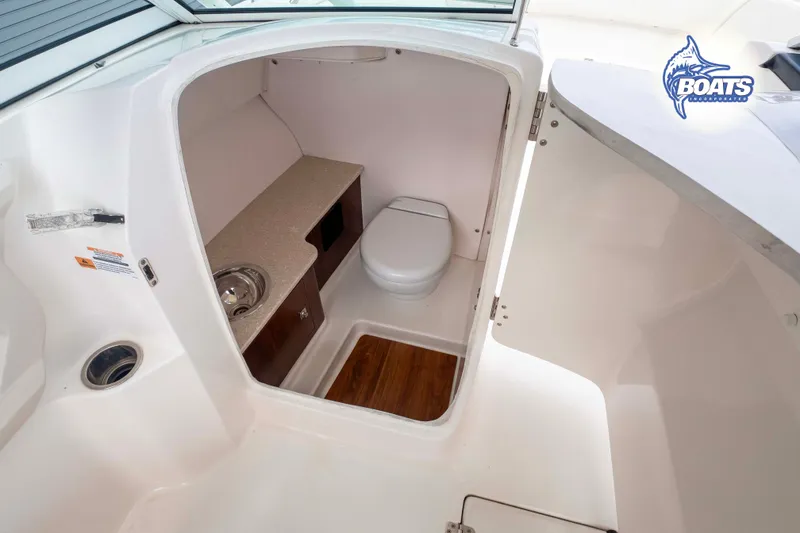 Slide: The Image of 2019 Robalo R247 Dual Console boat interior with compact bathroom and sink. - 6