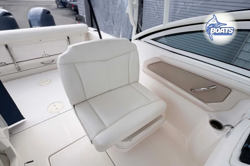 Slide: The Image of 2019 Robalo R247 Dual Console boat interior with white seating and storage compartment. - 7