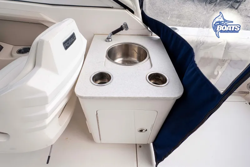 Slide: The Image of 2019 Robalo R247 Dual Console boat interior with sink and storage area. - 5