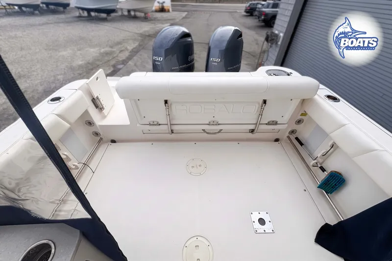 Slide: The Image of 2019 Robalo R247 Dual Console boat deck with twin 150 engines, docked outdoors. - 9