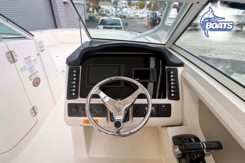 Slide: The Image of 2019 Robalo R247 Dual Console boat dashboard with steering wheel and controls. - 3