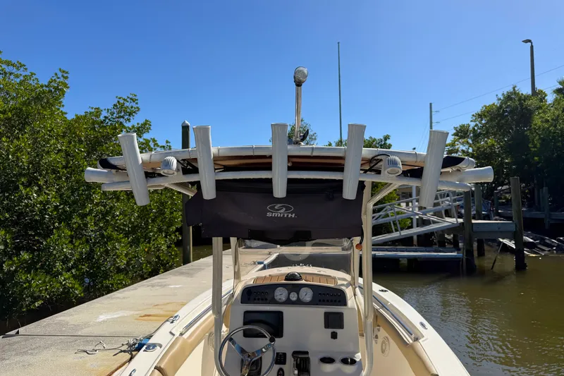 Slide: The Image of 2022 Pioneer 202 Islander boat docked, featuring a center console and rod holders. - 14