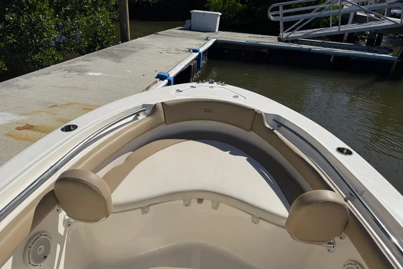 Slide: The Image of 2022 Pioneer 202 Islander boat interior at dock, featuring cushioned seating and sleek design. - 17