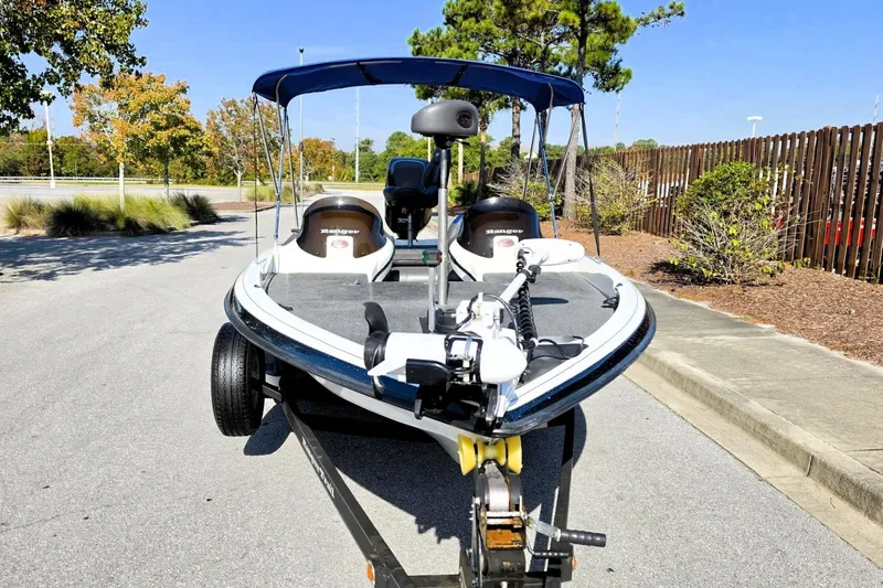 Slide: The Image of 2009 Ranger 208 VX boat on trailer, parked outdoors with trees in background. - 14
