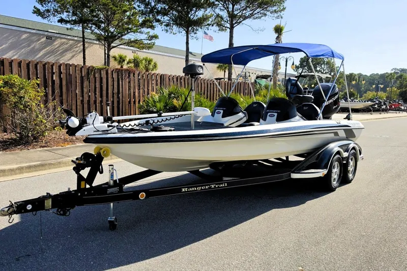 Slide: The Image of 2009 Ranger 208 VX boat on trailer with blue canopy, parked on street. - 12