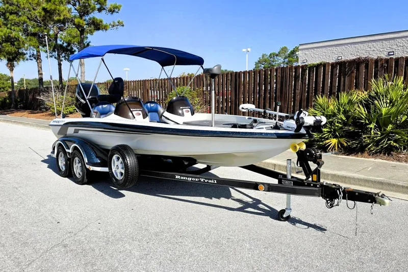 Slide: The Image of 2009 Ranger 208 VX boat with blue canopy on trailer, parked outdoors. - 11
