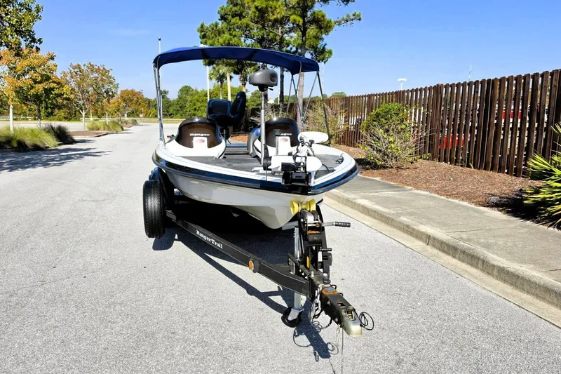 Slide: The Image of 2009 Ranger 208 VX boat on trailer, parked on a sunny street. - 13