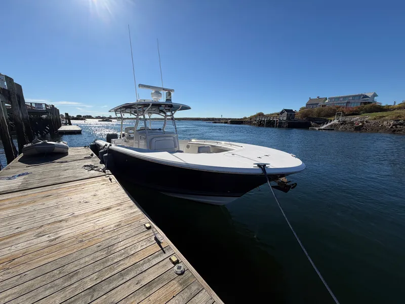 Slide: The Image of A 2016 Southport 33 FE docked at a wooden pier in a calm harbor. - 2