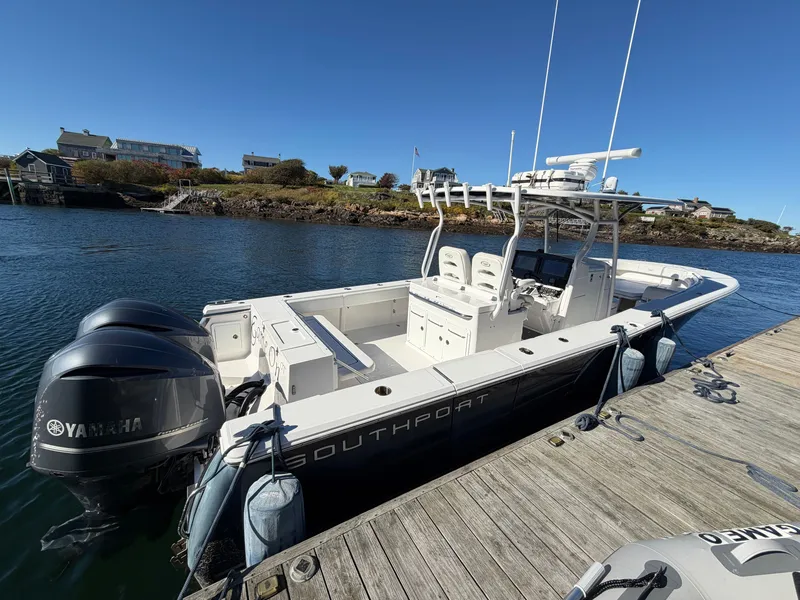The Image of A 2016 Southport 33 FE docked at a wooden pier. It features twin Yamaha outboard engines. - 1