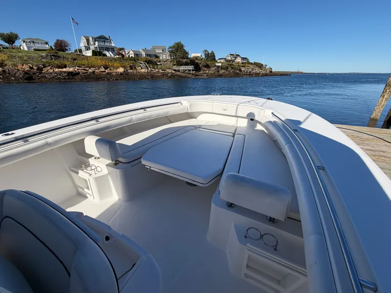 Slide: The Image of The image shows the bow of a 2016 Southport 33 FE boat, featuring seating and a table. - 12