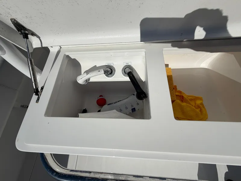 Slide: The Image of The image shows a sink with two faucets and cleaning supplies on a boat. - 17