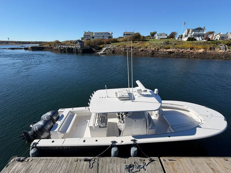 Slide: The Image of A 2016 Southport 33 FE docked in a calm bay, surrounded by coastal houses. - 3