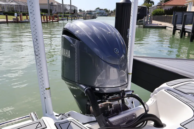 Slide: The Image of 2023 NauticStar 251 Hybrid boat with Yamaha outboard motor docked by waterfront homes. - 23