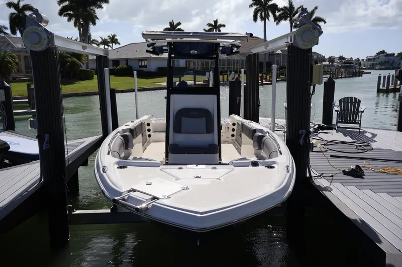 Slide: The Image of 2023 NauticStar 251 Hybrid boat docked at marina with palm trees in background. - 36