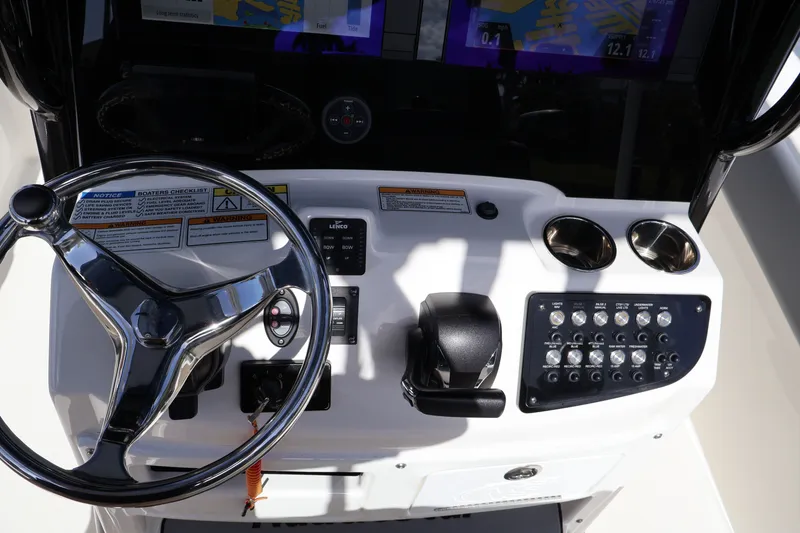 Slide: The Image of 2023 NauticStar 251 Hybrid boat dashboard with steering wheel and control panel. - 14
