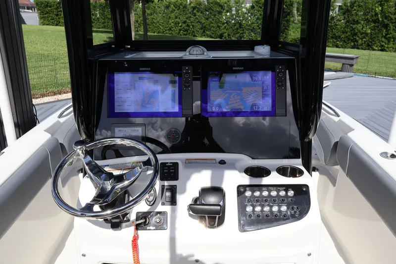 Slide: The Image of 2023 NauticStar 251 Hybrid boat dashboard with dual Simrad displays and steering wheel. - 30