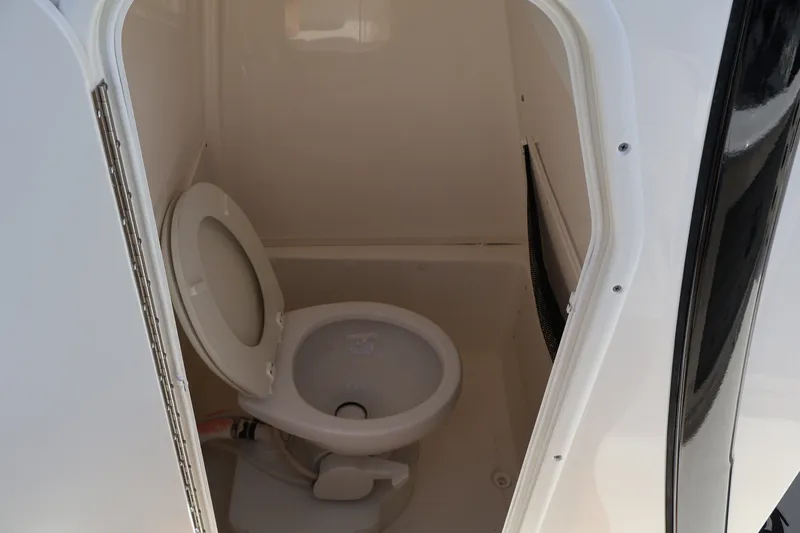 Slide: The Image of 2023 NauticStar 251 Hybrid boat interior toilet compartment. - 15