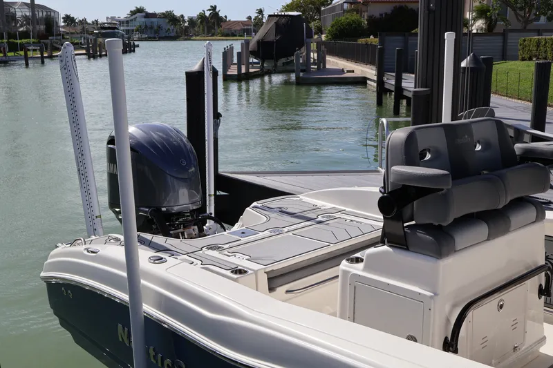 Slide: The Image of 2023 NauticStar 251 Hybrid boat docked in a serene waterfront setting. - 40