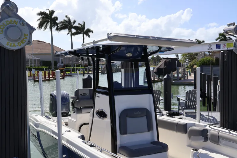 Slide: The Image of 2023 NauticStar 251 Hybrid boat docked in a sunny marina with palm trees. - 39