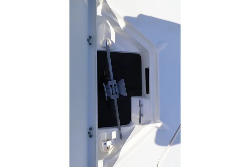 Slide: The Image of 2023 NauticStar 251 Hybrid boat anchor storage compartment with secured anchor and rope. - 33