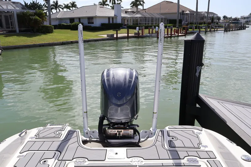 Slide: The Image of 2023 NauticStar 251 Hybrid boat docked, featuring a powerful outboard motor. - 20