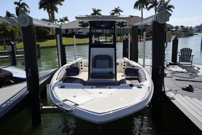 Slide: The Image of 2023 NauticStar 251 Hybrid boat docked at marina with palm trees in background. - 44