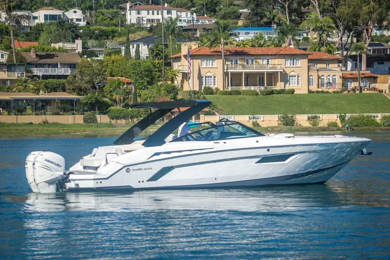 Slide: The Image of 2020 Cruisers Sport Series 338 Bow Rider on water, luxury homes in background. - 5