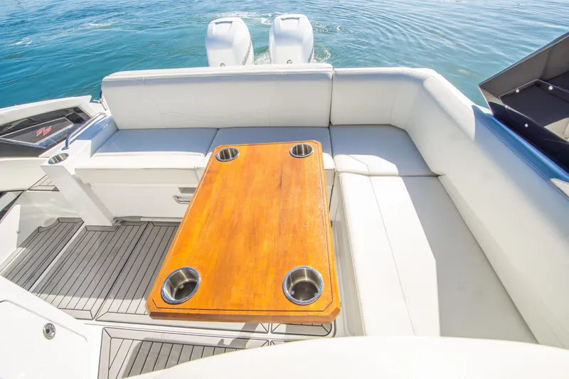 Slide: The Image of 2020 Cruisers Sport Series 338 Bow Rider interior with wooden table and white seating. - 12