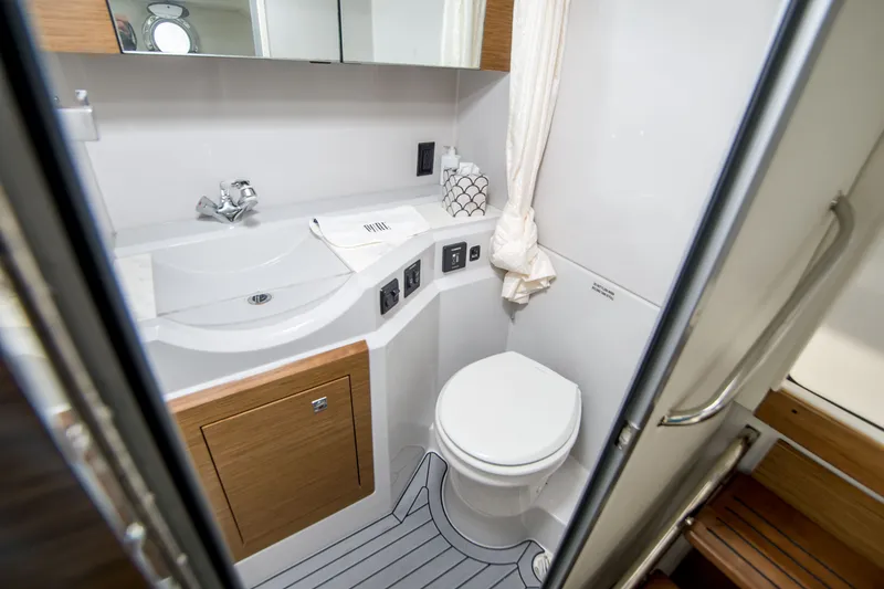 Slide: The Image of 2020 Cruisers Sport Series 338 Bow Rider bathroom with modern fixtures and wooden accents. - 38