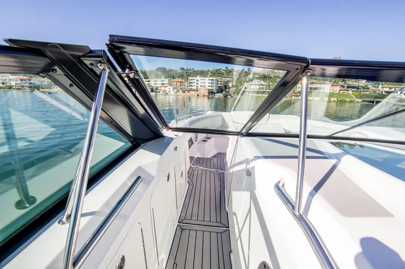 Slide: The Image of 2020 Cruisers Sport Series 338 Bow Rider, sleek deck view, modern design, waterfront backdrop. - 25