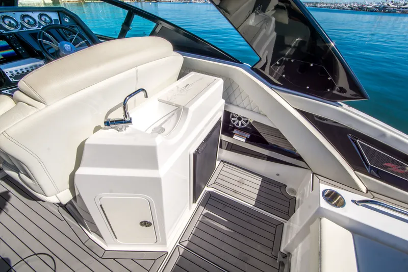 Slide: The Image of 2020 Cruisers Sport Series 338 Bow Rider interior with helm, sink, and seating. - 15