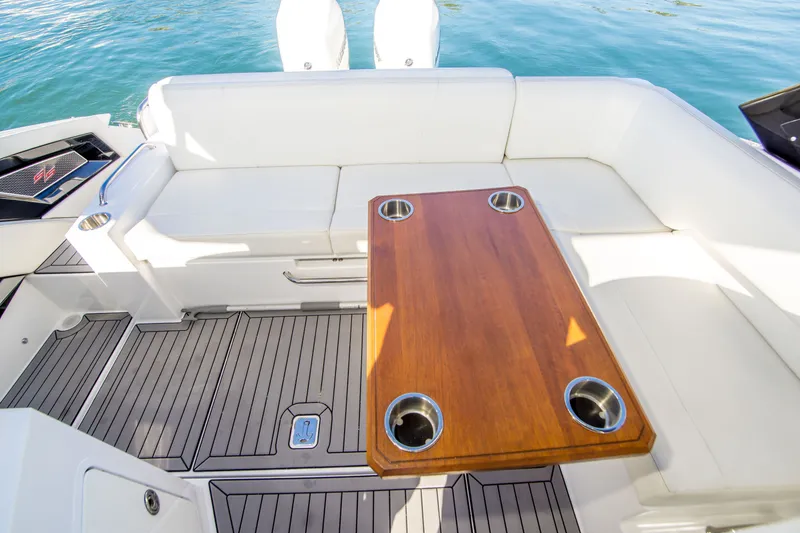 Slide: The Image of 2020 Cruisers Sport Series 338 Bow Rider interior with white seating and wooden table. - 14