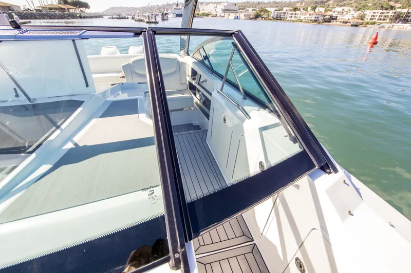 Slide: The Image of 2020 Cruisers Sport Series 338 Bow Rider on calm water, showcasing sleek design and spacious deck. - 27