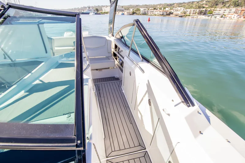 Slide: The Image of 2020 Cruisers Sport Series 338 Bow Rider on calm water, showcasing sleek deck design. - 26