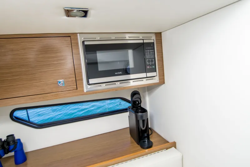 Slide: The Image of 2020 Cruisers Sport Series 338 Bow Rider interior with microwave and coffee maker. - 37
