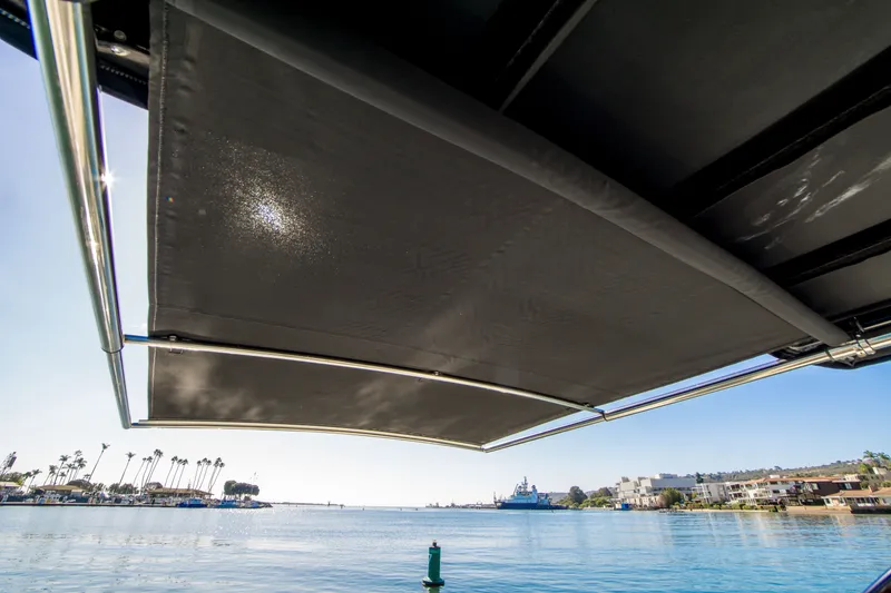 Slide: The Image of 2020 Cruisers Sport Series 338 Bow Rider with sunshade on a sunny waterfront. - 23