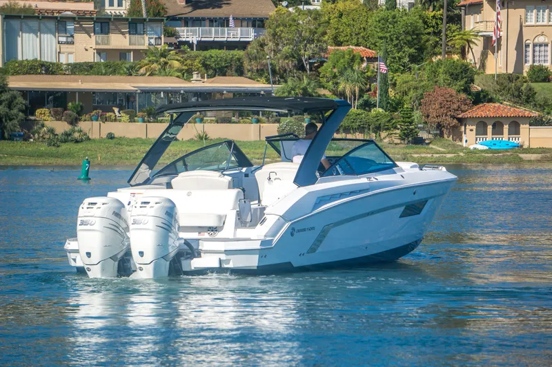 Slide: The Image of 2020 Cruisers Sport Series 338 Bow Rider on water near luxury homes. - 6