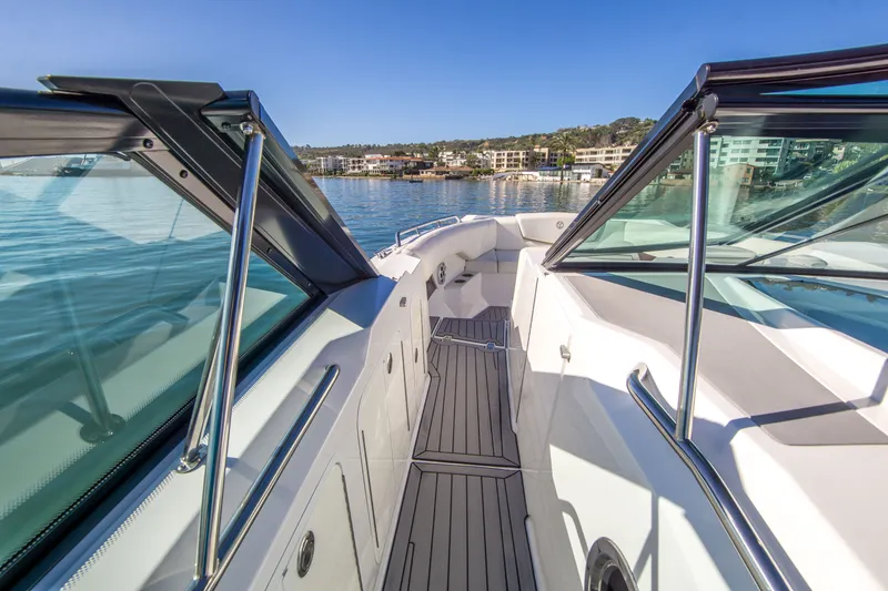 Slide: The Image of 2020 Cruisers Sport Series 338 Bow Rider on calm water, showcasing sleek design and spacious deck. - 24