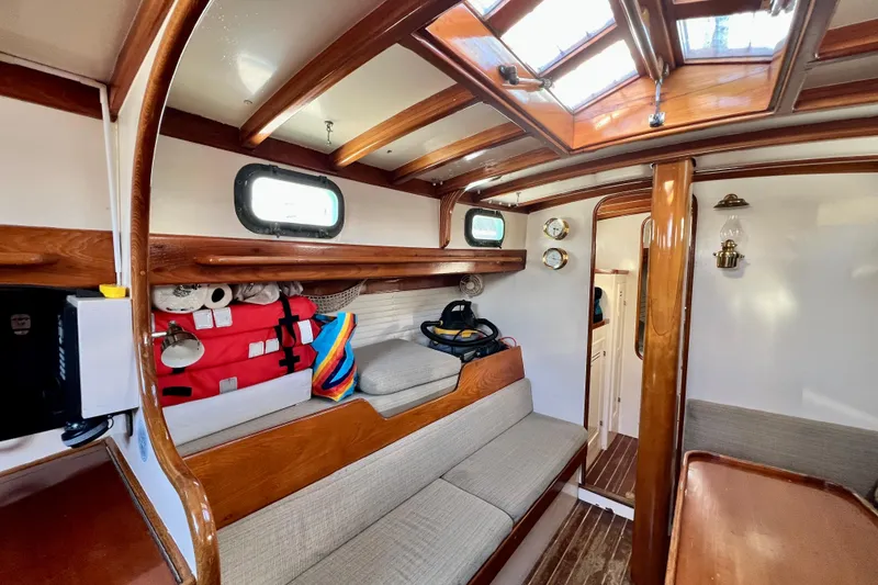 Slide: The Image of Interior of 1975 Cape George 36 sailboat with wooden accents and cozy seating area. - 52