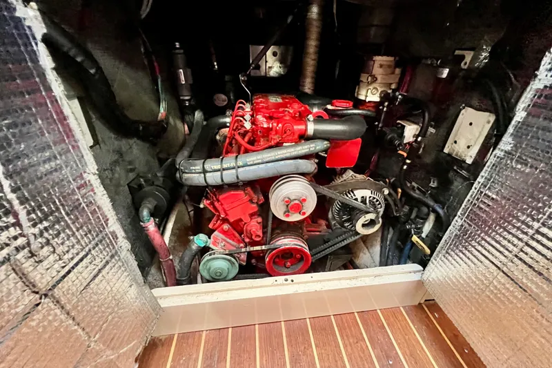 Slide: The Image of Engine compartment of a 1975 Cape George 36 sailboat, featuring a red marine engine. - 75