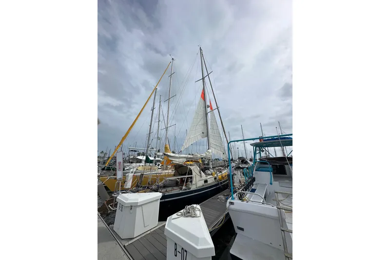Slide: The Image of Sailboat docked at marina, Cape George 36, 1975 model, under cloudy sky. - 38