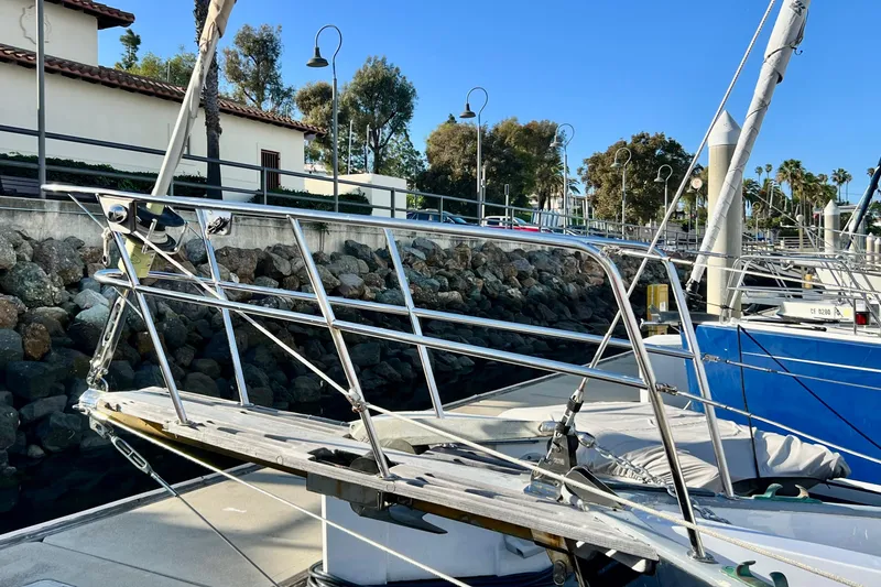 Slide: The Image of 1975 Cape George 36 sailboat docked, featuring stainless steel bow and marina backdrop. - 8