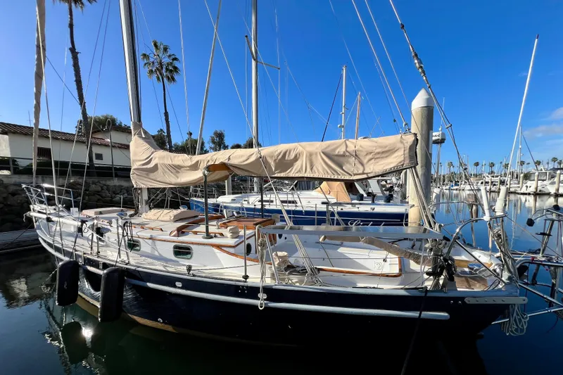 Slide: The Image of 1975 Cape George 36 sailboat docked in a marina under clear blue skies. - 10