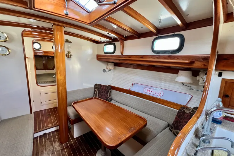 Slide: The Image of Interior of a 1975 Cape George 36 sailboat with wooden accents and cozy seating area. - 58