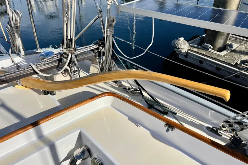 Slide: The Image of Wooden tiller on a 1975 Cape George 36 sailboat, docked with visible rigging. - 29