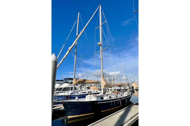 The Image of Cape George 36 sailboat from 1975 docked at marina under clear blue sky. - 0