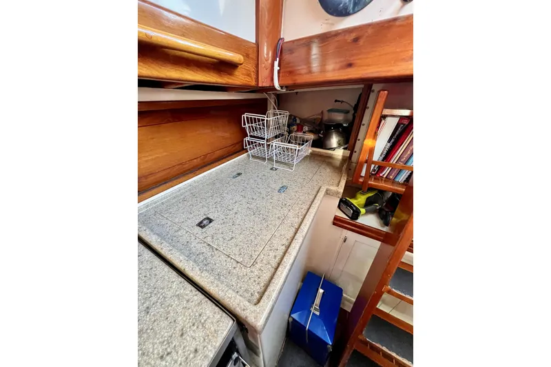 Slide: The Image of Galley kitchen in 1975 Cape George 36 sailboat with wooden cabinetry and granite countertop. - 70