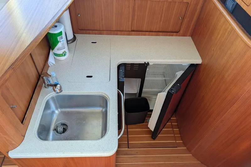 Slide: The Image of 2006 Tiara Yachts 3900 Convertible galley with sink, countertop, and mini fridge. - 27