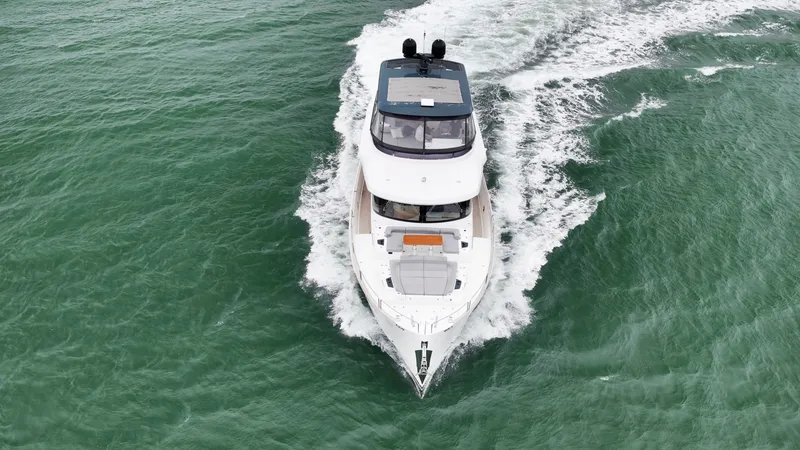 Slide: The Image of The 2020 Sirena 64 cruises through green water, featuring a sleek design and spacious deck. - 6