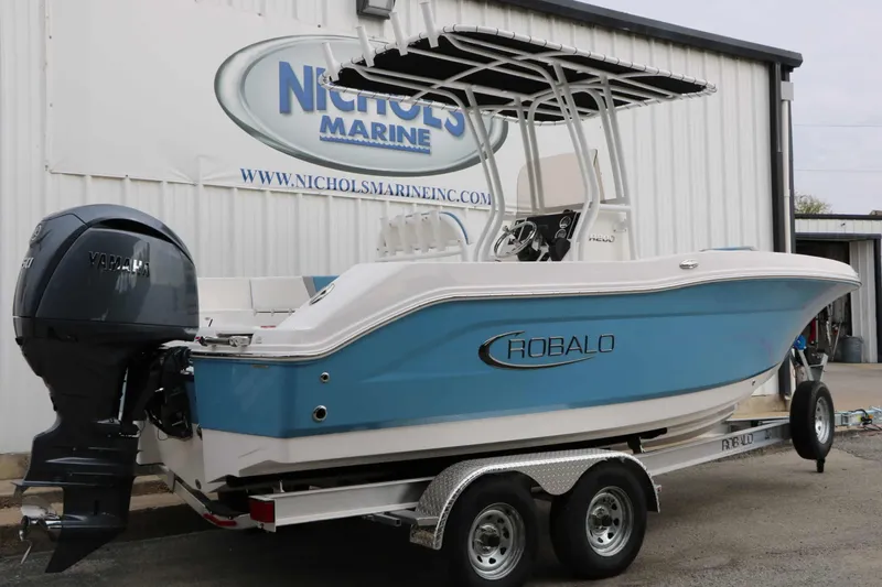 Slide: The Image of A blue and white Robalo R200 Center Console boat on a trailer in front of a building. - 13